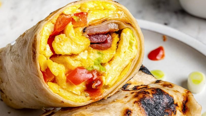 Breakfast burritos with scrambled eggs, sliced open