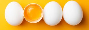Eggs, one cracked open showing the yolk